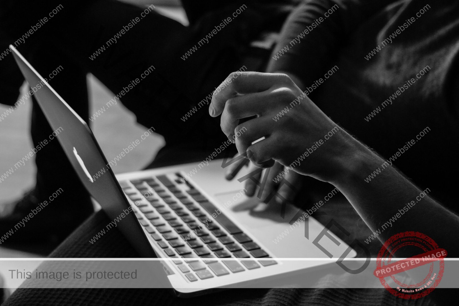 grayscale photo of person using MacBook
